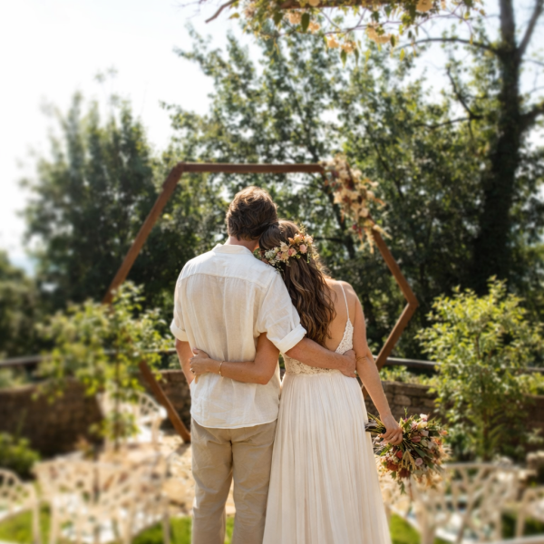 Hochzeitspaar von hinten vor Kulisse mit Raute